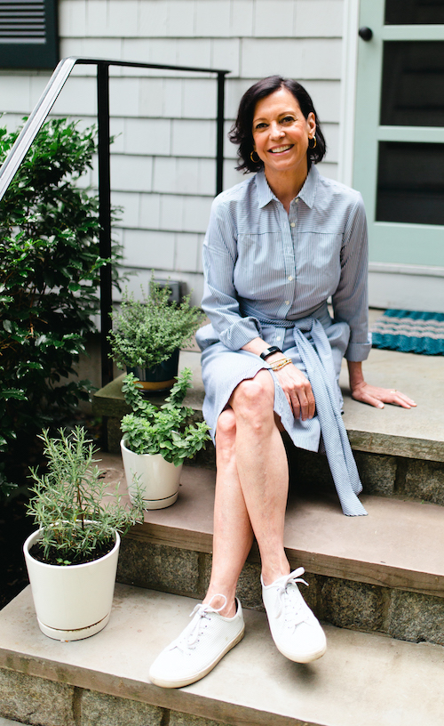 Jenn Redmond sitting on stairs next to pots of herbs